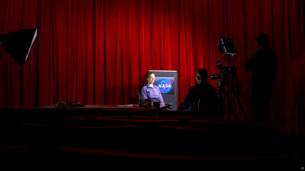 Video shoot in NASA with one person on camera and two people behind the scenes. The NASA logo is seen in the background